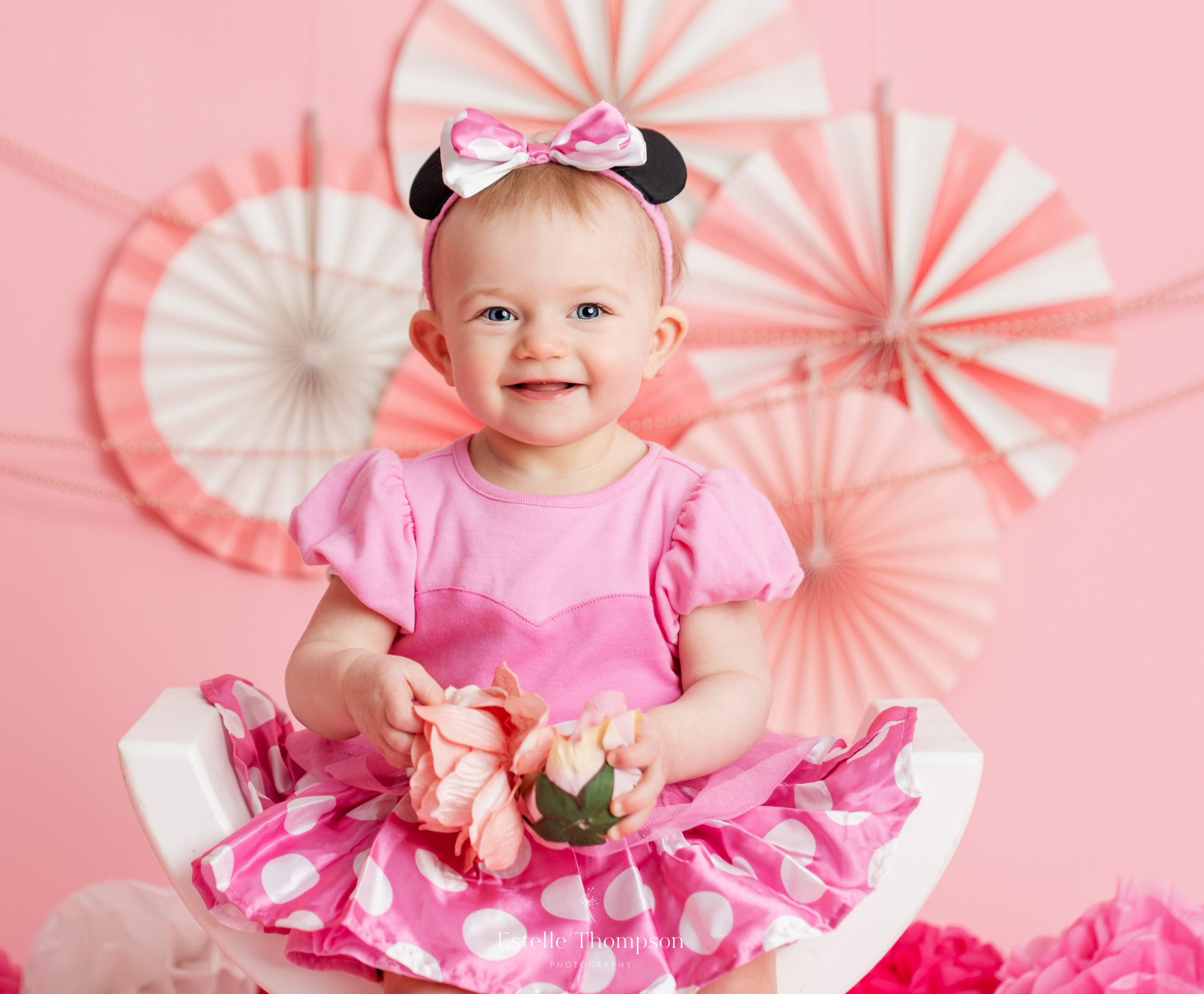 A little girl poses for her first birthday photos in a sevenoaks cake smash