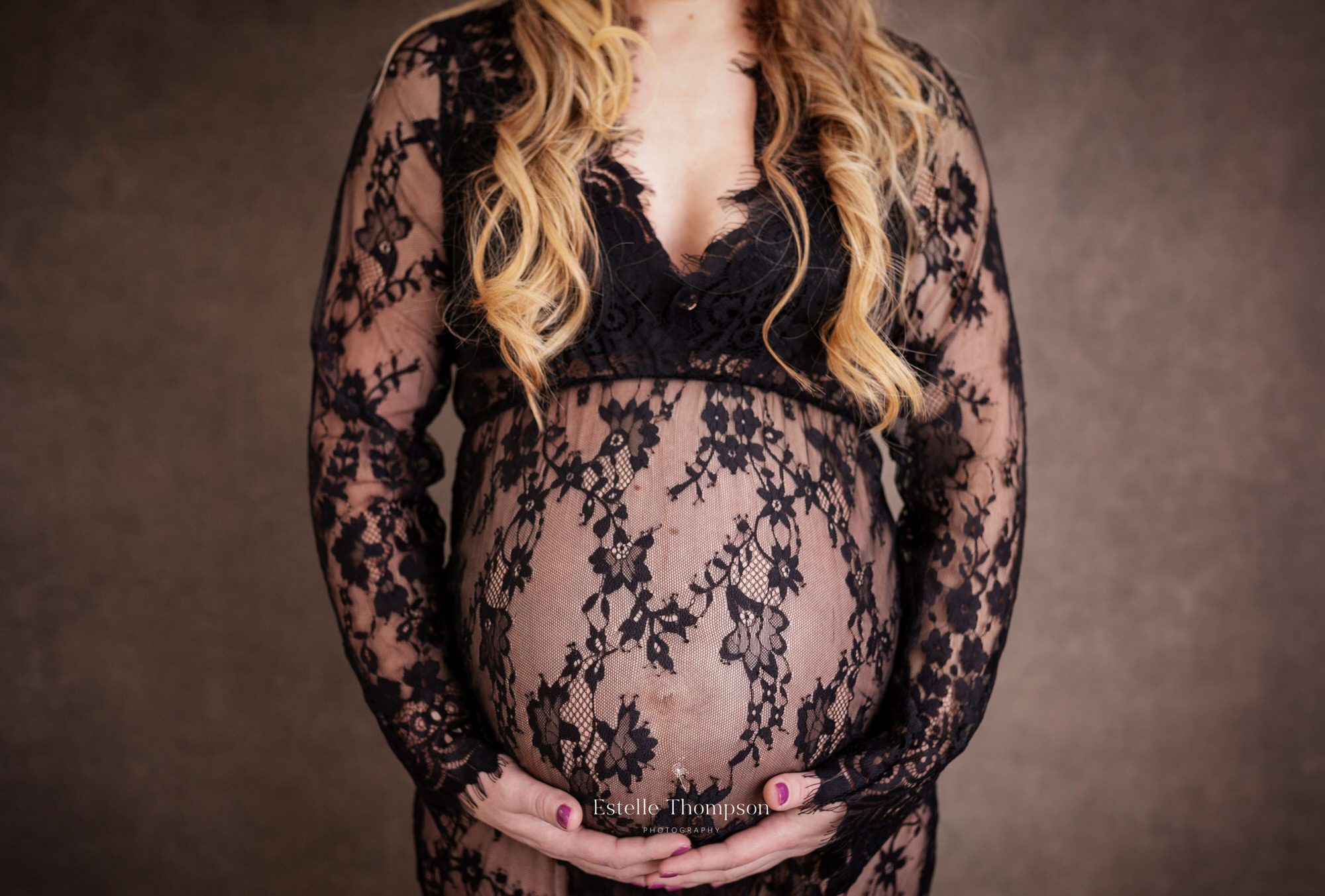 Pregnant lady holds her bump in maternity photoshoot at kent maternity photography studio
