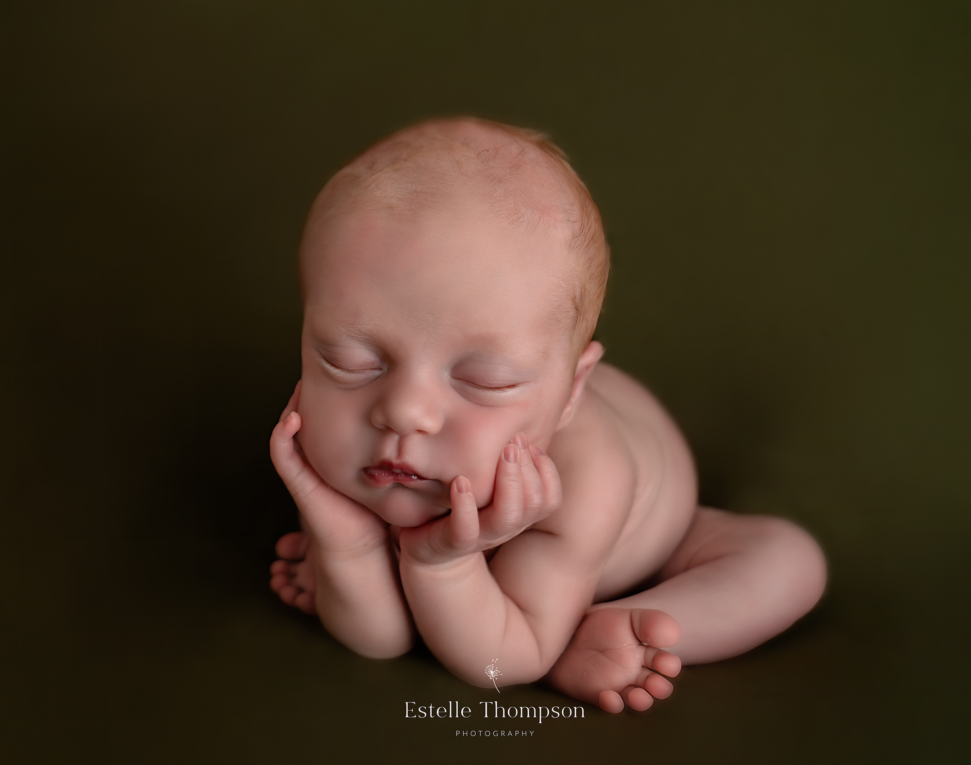 a newborn baby lays with her head in her hands on a newborn photoshoot in sevenoaks