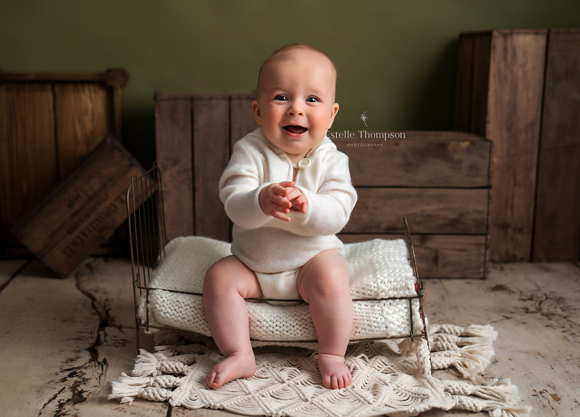 baby boy sitting on a bed at a baby photoshoot