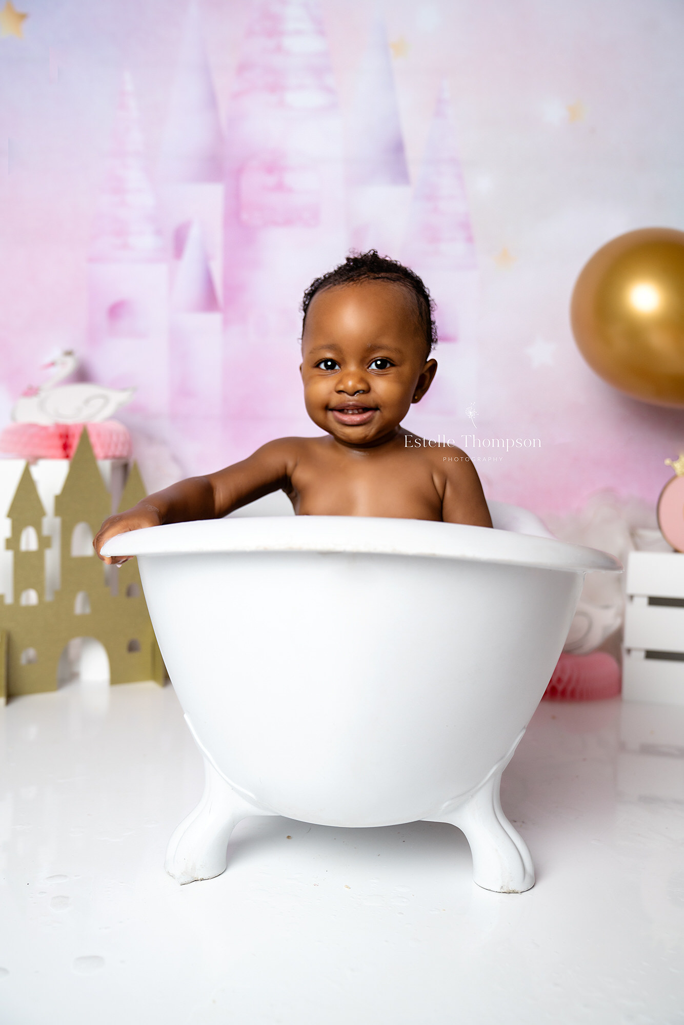 Baby girl in the bathtub after her cake smash photoshoot
